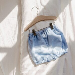 a pair of blue shorts hanging on a hanger